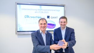 Ein Foto von Prof. Dr. Joachim Burghartz und Michael Förtsch, die vor einem Bildschirm gemeinsam einen Wafer halten.